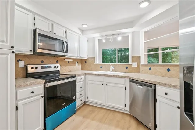 a kitchen with granite countertop cabinets stainless steel appliances and a sink