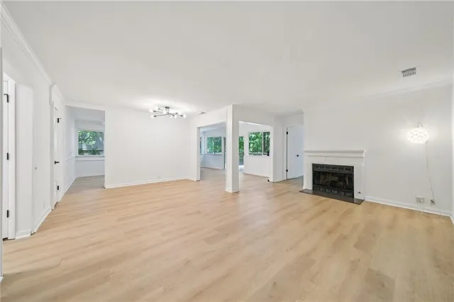 an empty room with windows and fireplace