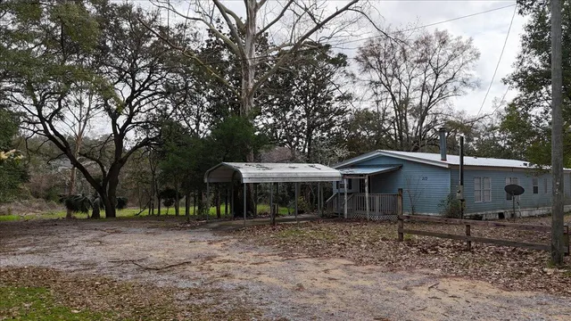 a view of a house with a yard and hanging chair