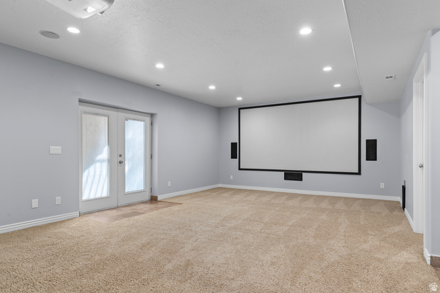 1501 West Elk Circle Mapleton, UT 84664 - Photo 32 of 39 Spacious entertainment room featuring a large projection screen, built-in speakers, recessed lighting, and soft carpeting