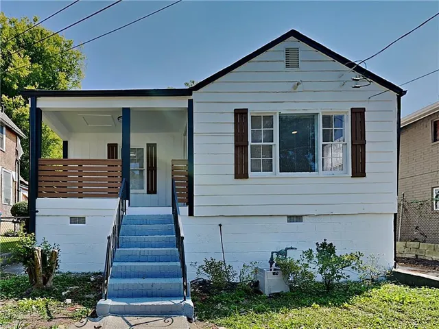 a front view of a house with potted plants