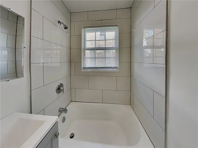 a bathroom with a tub a sink and a shower