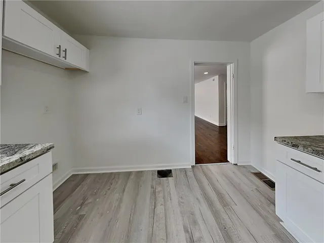 a view of a kitchen with wooden floor and a stove top oven