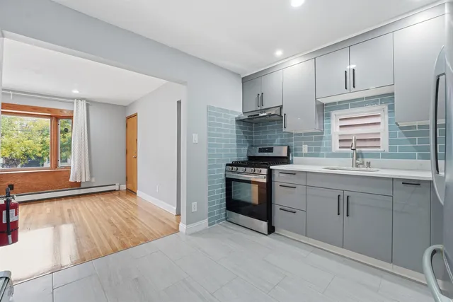 a kitchen with kitchen island a counter top space stainless steel appliances and cabinets