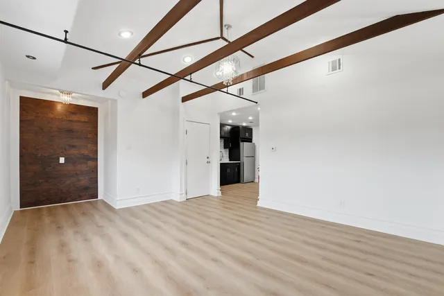 a view of an empty room with a kitchen