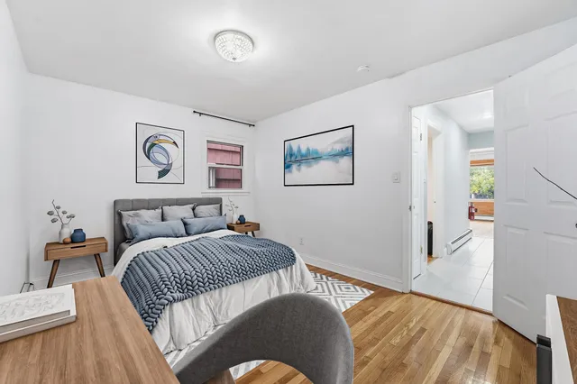 an empty room with wooden floor and mirror