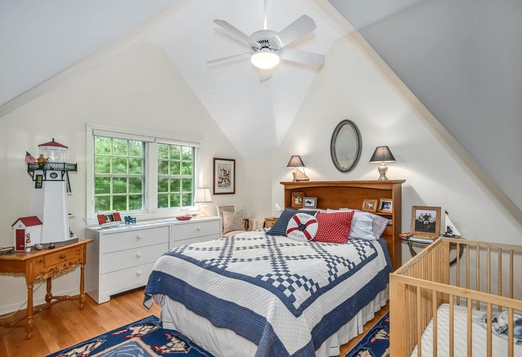 123 Long Neck Point Road Darien, CT 06820 - Photo 25 of 41 a bedroom with a bed and a chandelier