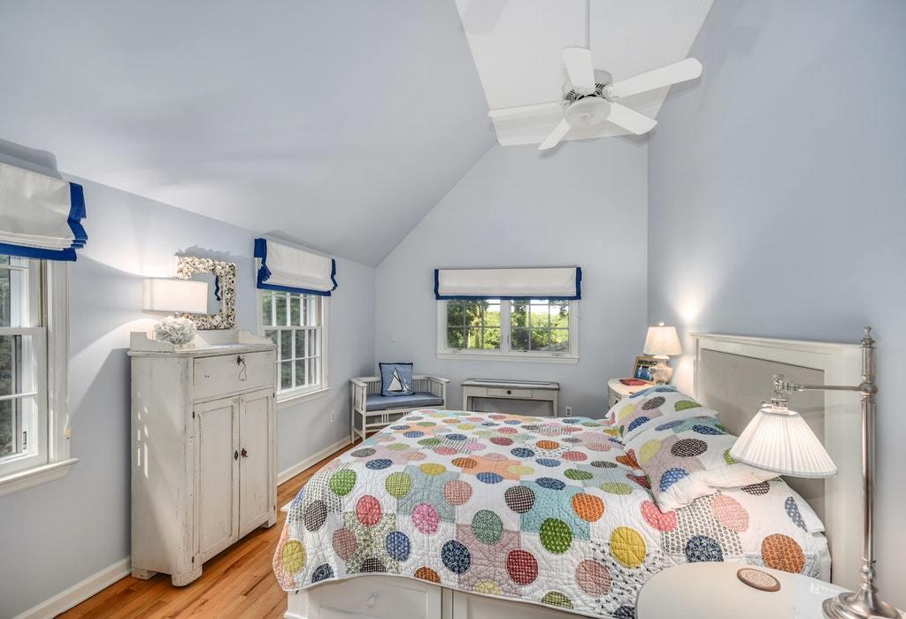 123 Long Neck Point Road Darien, CT 06820 - Photo 28 of 41 a bedroom with a bed and a chandelier