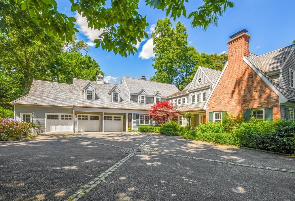 123 Long Neck Point Road Darien, CT 06820 - Photo 4 of 41 a view of a white house next to a yard with plants and large trees