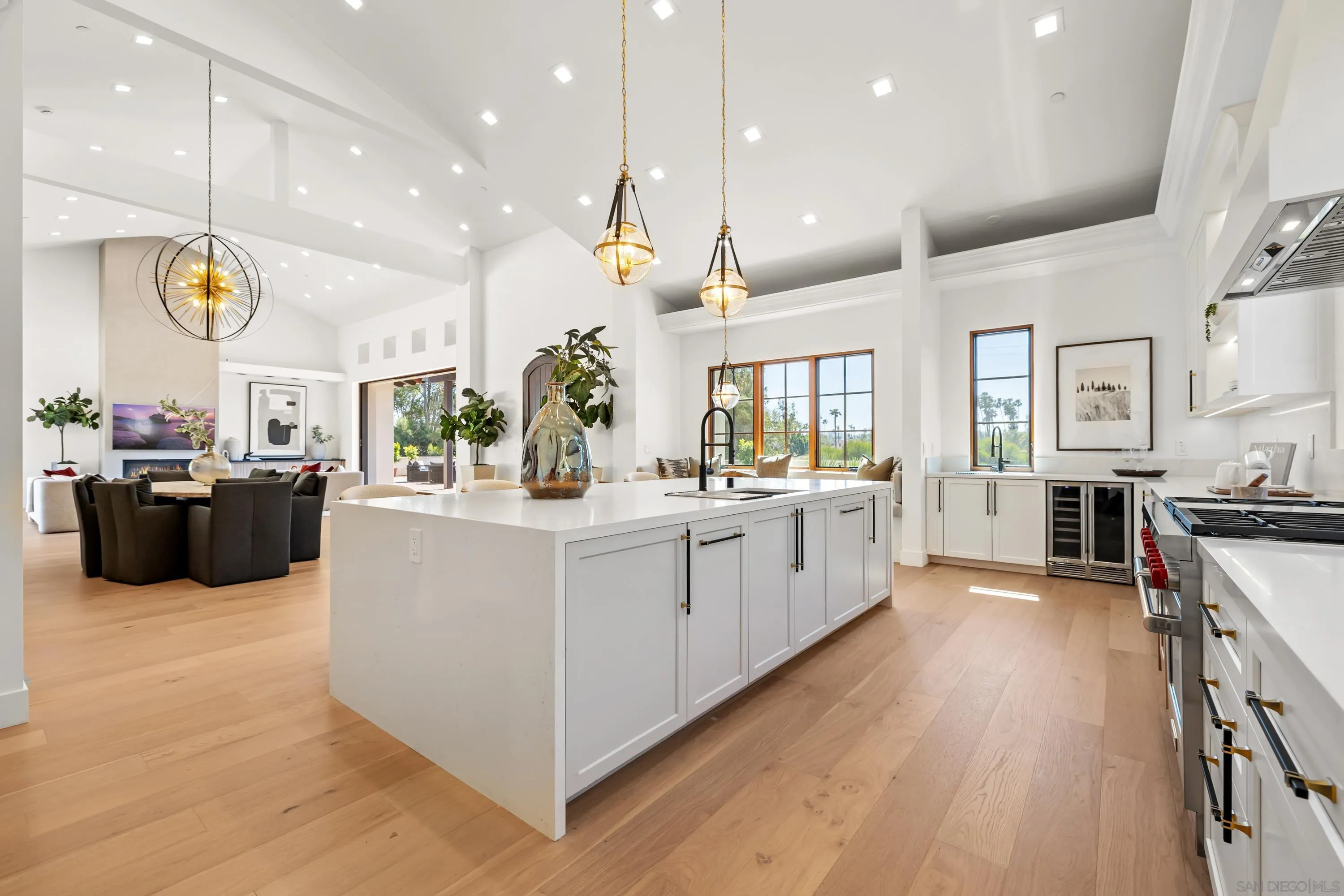 5758-60 Las Palomas Rancho Santa Fe, CA 92067 - Photo 19 of 64 a large white kitchen with a large counter top stainless steel appliances and lots of wooden floors