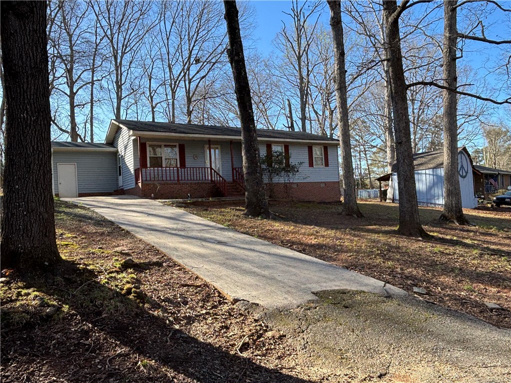 112 Ross Drive Starr, SC 29684 - Photo 3 of 23 A charming single-story home nestled among mature trees offers a serene living environment.