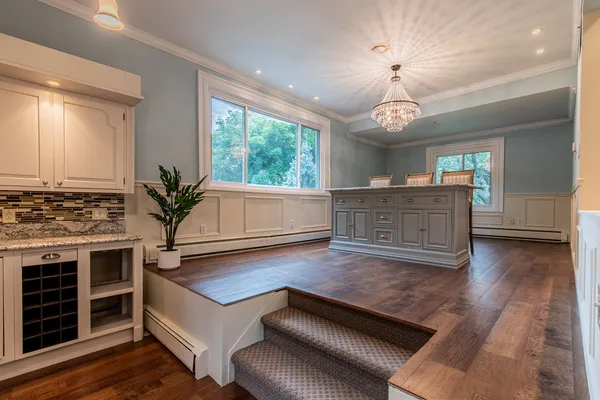 a spacious bathroom with a granite countertop sink a mirror and a window