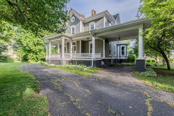 a front view of a house with a yard and potted plants