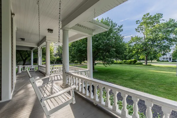 a view of a chair and tables in the patio next to a yard