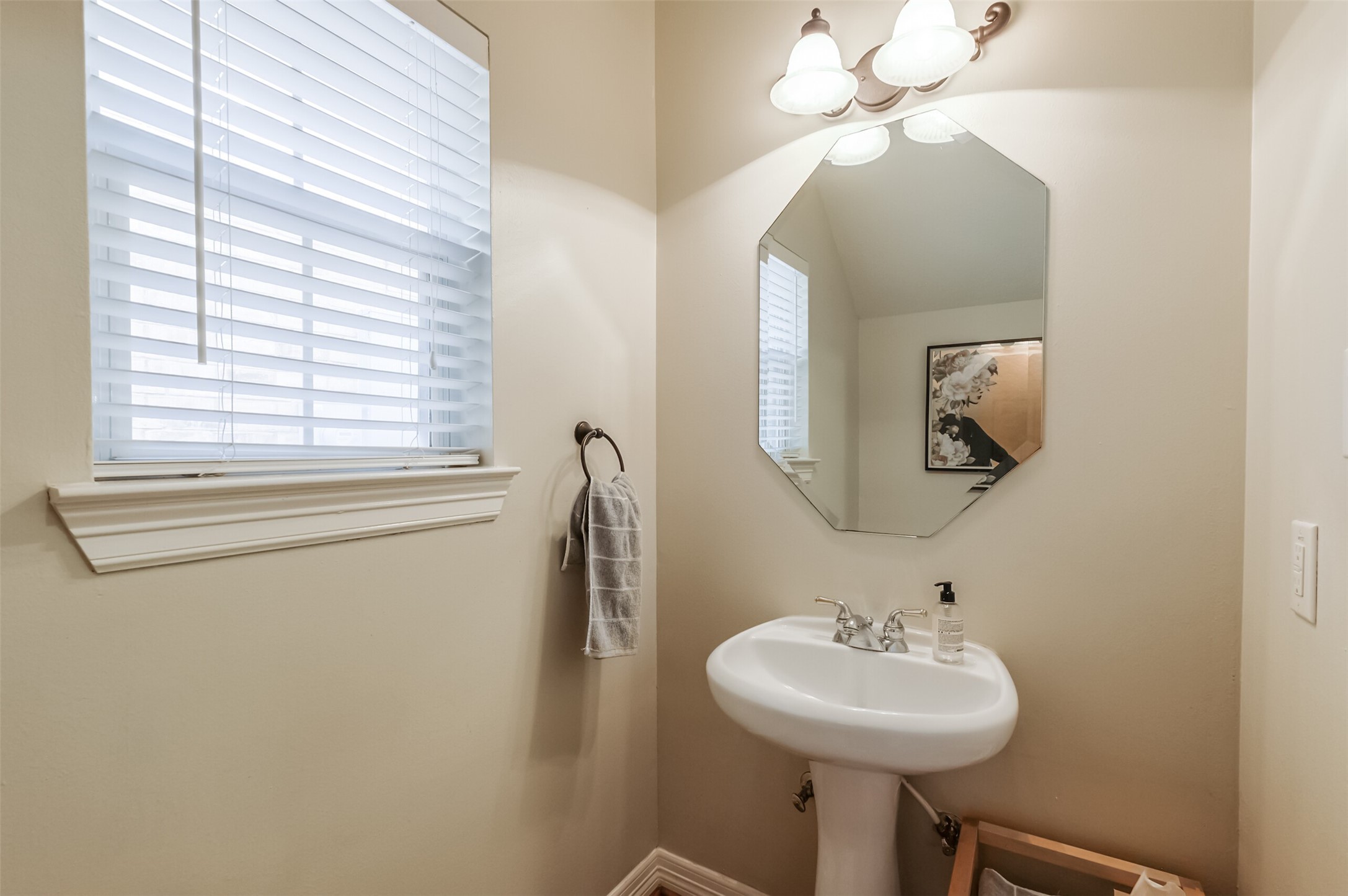 7515 Shady Villa Walk Houston, TX 77055 - Photo 18 of 23 Powder room is located just off the entry with a pedestal sink, decorative mirror and vanity light. Also in the hallway is an under stair storage closet.
