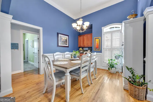 a view of a dining room with furniture a chandelier and wooden floor