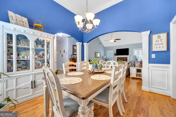 a view of a dining room with furniture a chandelier and wooden floor