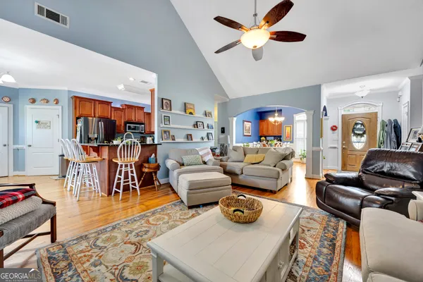 a living room with furniture and a view of kitchen