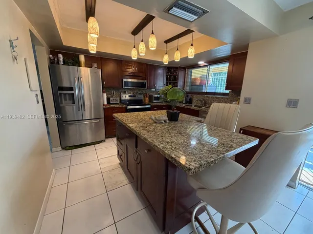 a bathroom with a granite countertop sink a toilet and shower