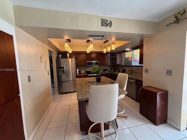 a kitchen with a refrigerator and a stove