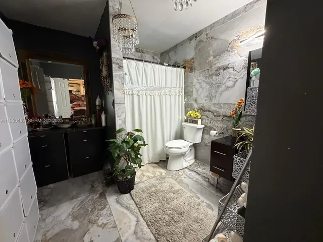 a bathroom with a sink and mirror with toilet