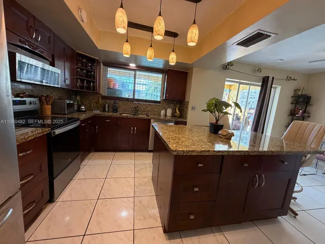 a kitchen with a sink a counter top space and stainless steel appliances