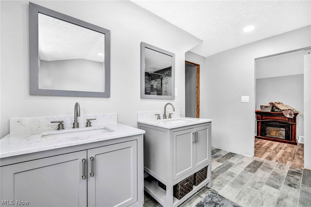 7983 Wadsworth Road Medina, OH 44256 - Photo 22 of 42 Bathroom with wood-type flooring, a textured ceiling, and dual bowl vanity