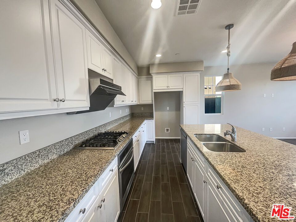 7396 Solstice Place Rancho Cucamonga, CA 91739 - Photo 11 of 18 a kitchen with granite countertop stainless steel appliances sink stove microwave and cabinets