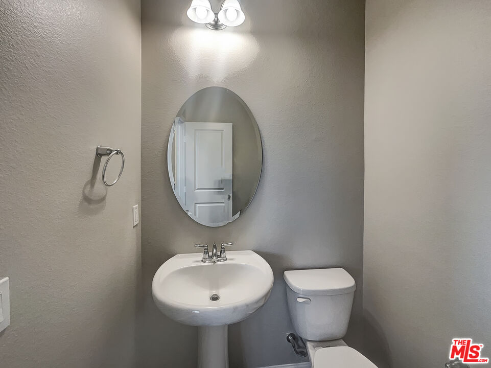 7396 Solstice Place Rancho Cucamonga, CA 91739 - Photo 13 of 18 a bathroom with a toilet sink and mirror