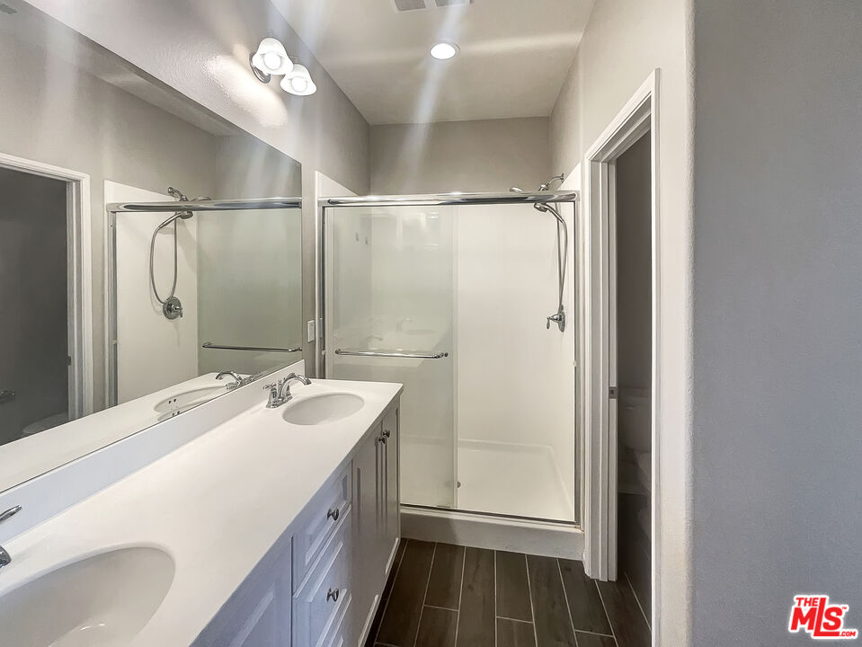 7396 Solstice Place Rancho Cucamonga, CA 91739 - Photo 17 of 18 a bathroom with a double vanity sink mirror and shower