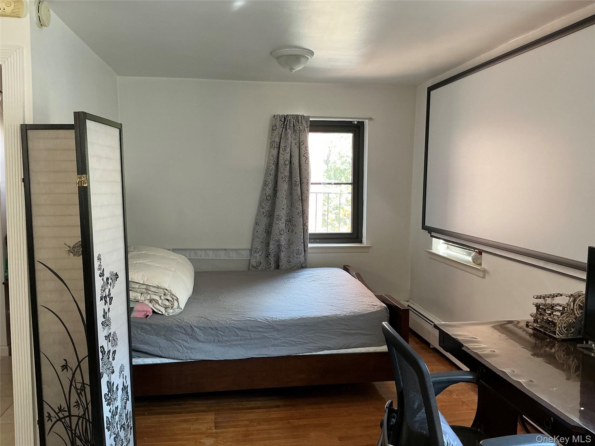 99-11 60th Avenue, Unit 3A Queens, NY 11368 - Photo 4 of 22 Bedroom with wood finished floors and an office area