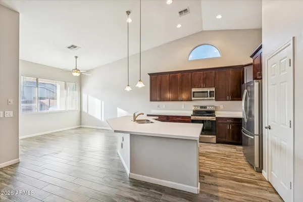 a kitchen with kitchen island a sink stainless steel appliances and cabinets