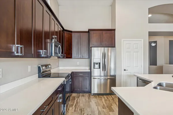 a kitchen with stainless steel appliances a sink cabinets and wooden floor