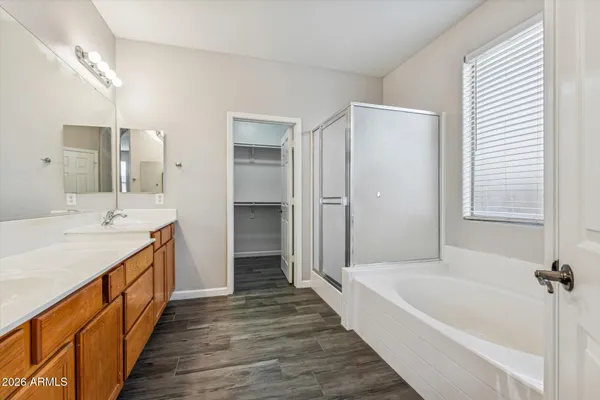 a spacious bathroom with a tub sink shower and mirror