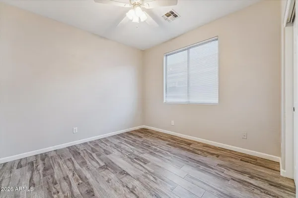 an empty room with wooden floor and windows