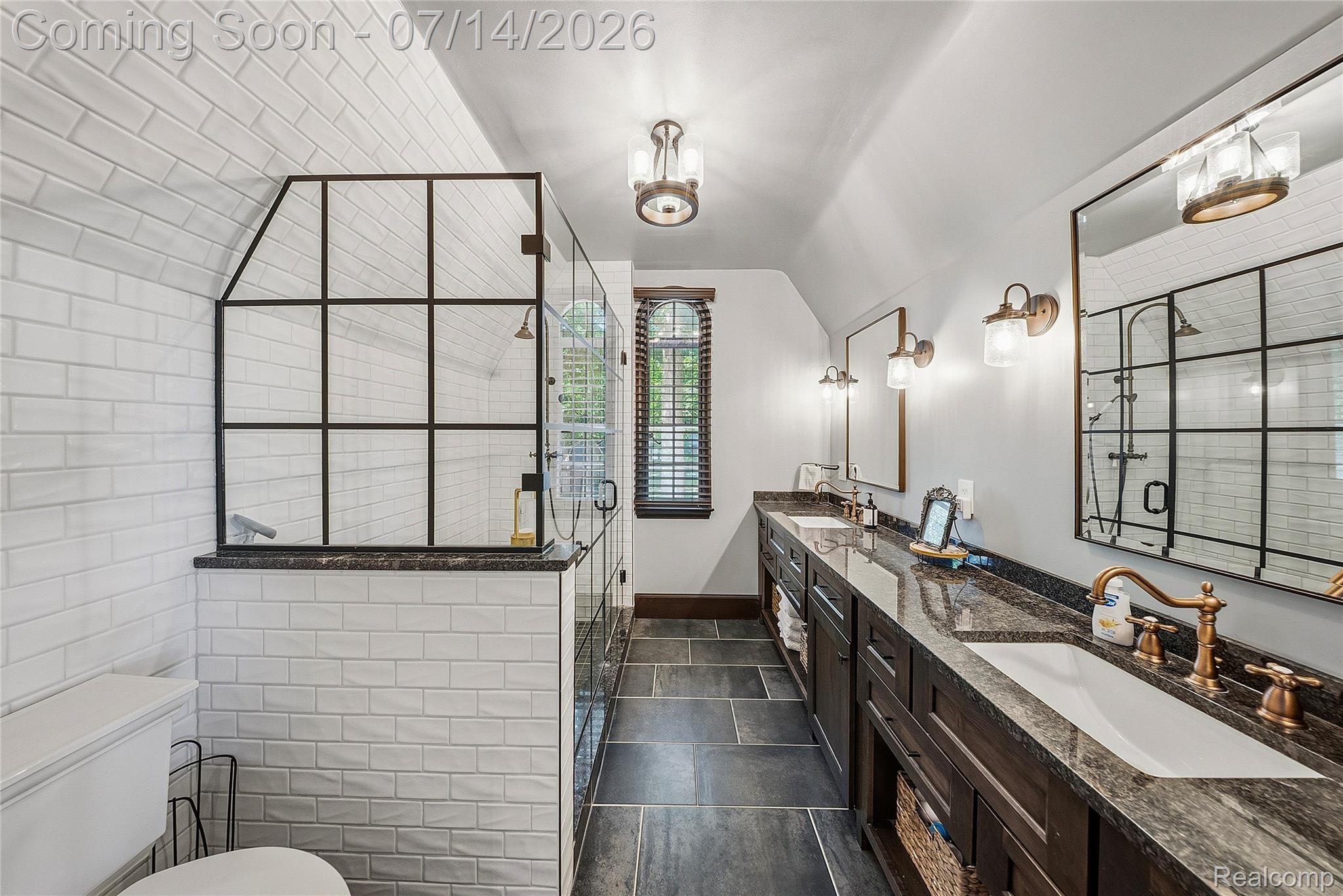 18460 Meridian Road Grosse Ile, MI 48138 - Photo 36 of 50 Spacious bathroom featuring a glass-enclosed shower with grid detailing, double vanity with stone countertops, individual mirrors, and slate tile flooring