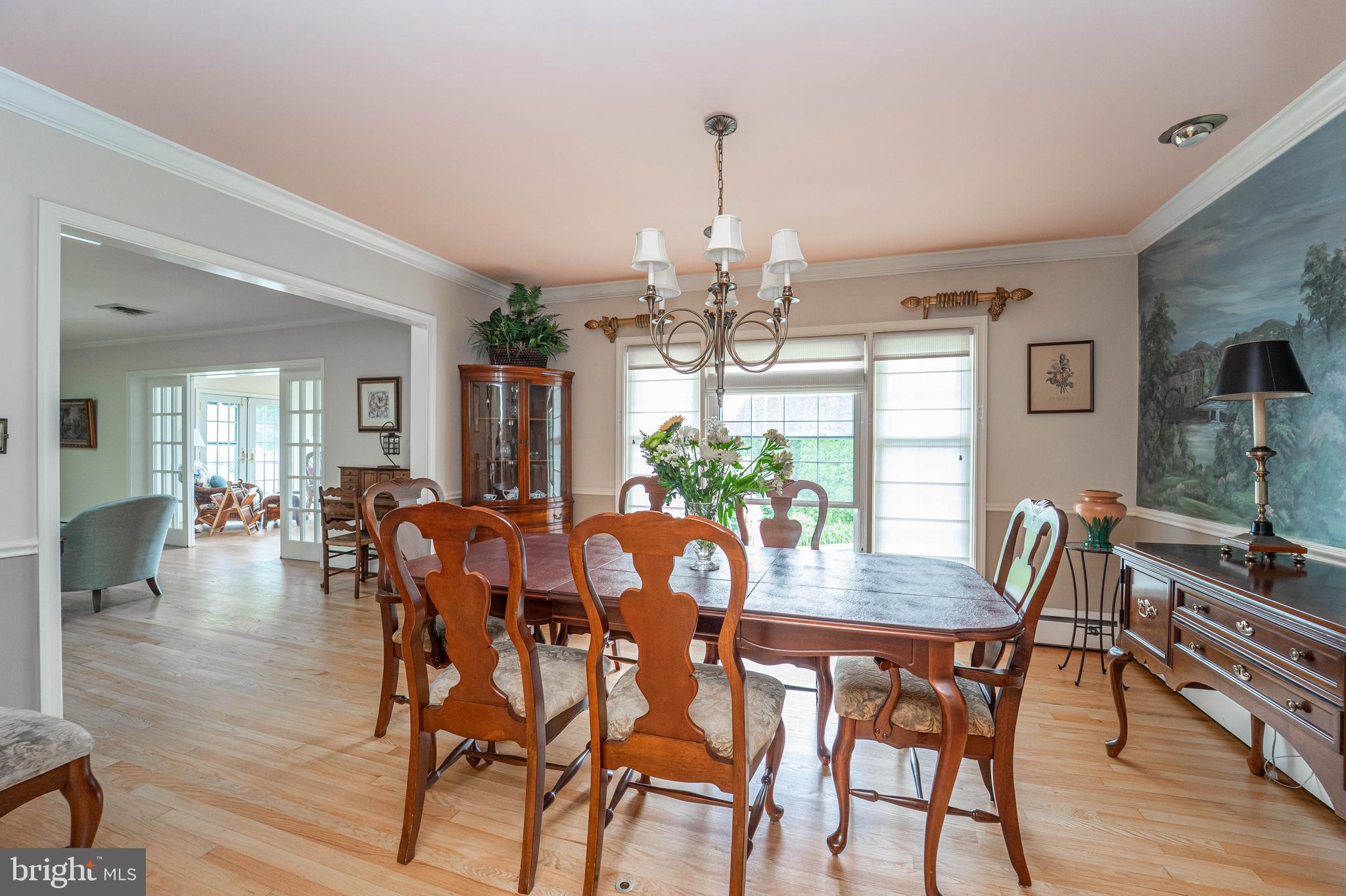 605 St Francis Road Baltimore, MD 21286 - Photo 17 of 56 a view of a dining room and livingroom with furniture wooden floor a chandelier
