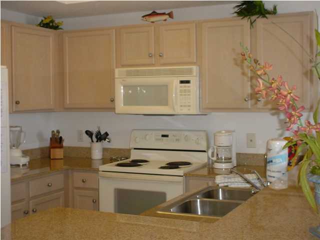 590 Santa Rosa Boulevard, Unit 213 Fort Walton Beach, FL 32548 - Photo 5 of 9 a kitchen with stainless steel appliances white cabinets and a stove