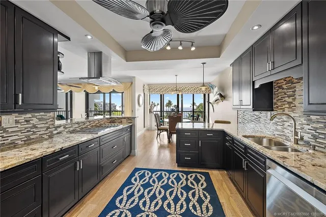 a large kitchen with stainless steel appliances granite countertop a sink stove and refrigerator