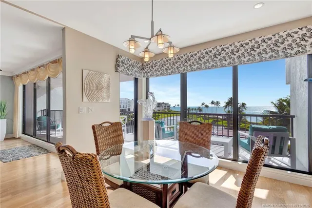 a dining room with furniture a chandelier and wooden floor