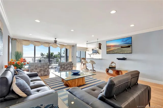 a living room with furniture kitchen view and a large window