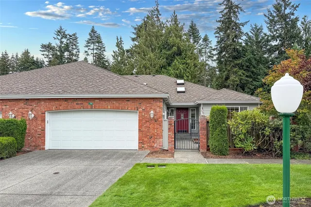 a front view of a house with a garden and yard