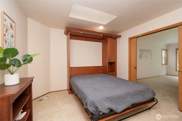 a bedroom with a bed and a potted plant