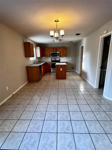 a kitchen with stainless steel appliances a sink a counter top space cabinets and a window