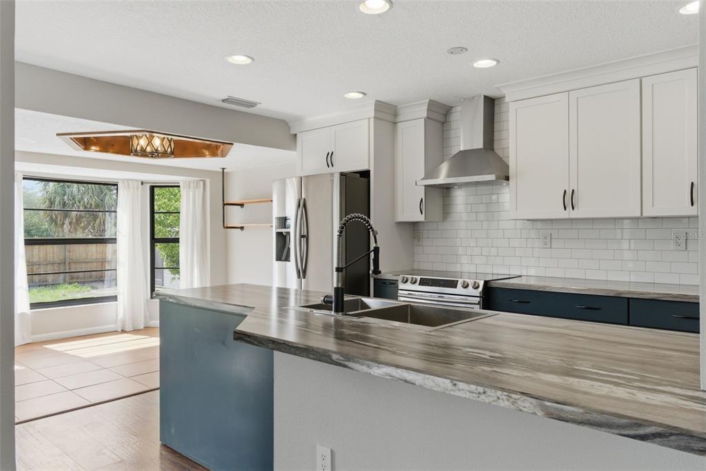 4966 Keysville Avenue Spring Hill, FL 34608 - Photo 20 of 48 a kitchen with stainless steel appliances granite countertop a sink and a refrigerator