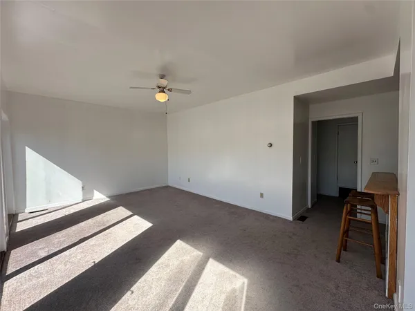 an empty room with a fan and a ceiling fan