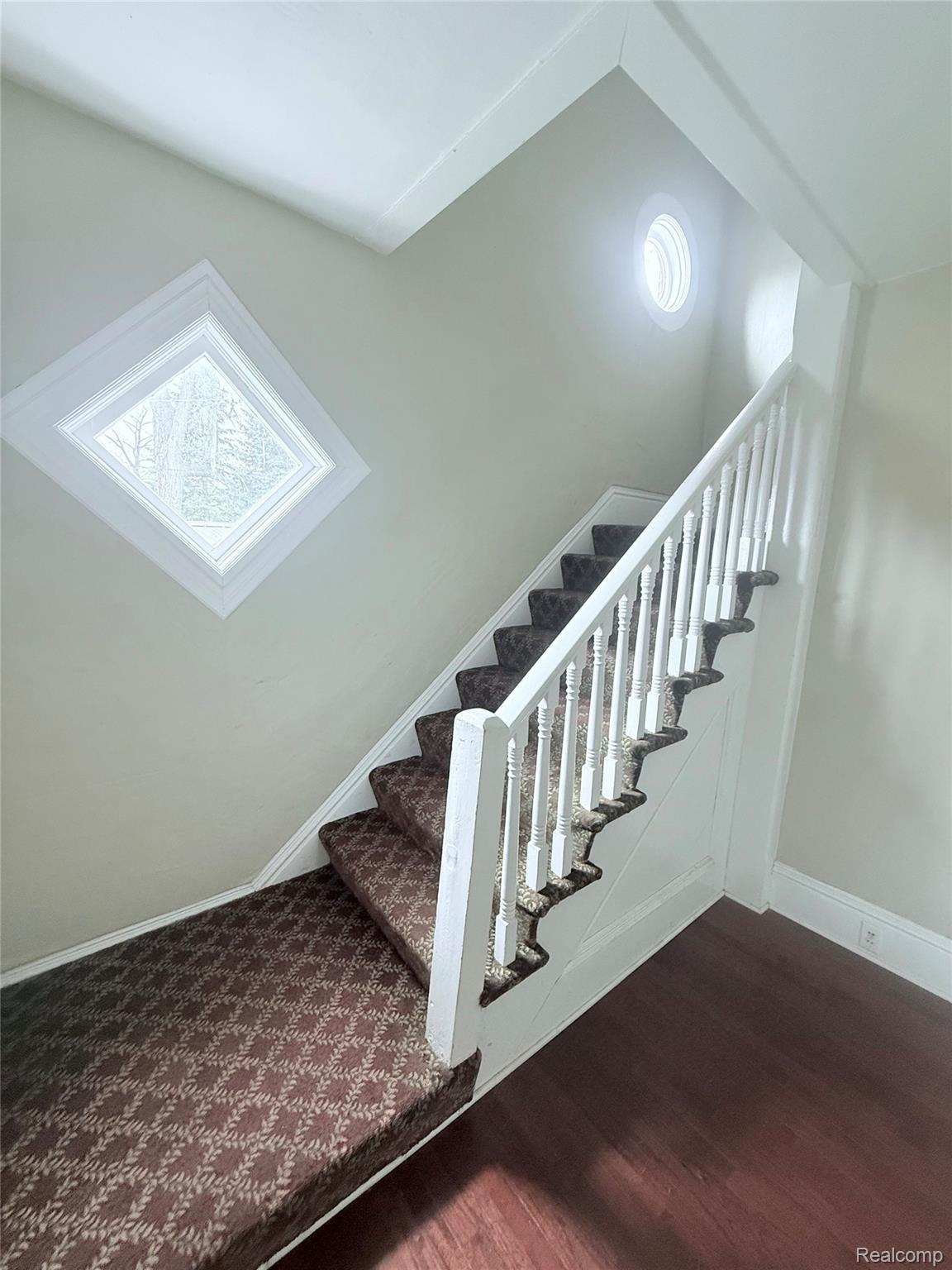 415 Coutant Street, Unit B Flushing, MI 48433 - Photo 2 of 11 Staircase featuring wood finished floors and baseboards