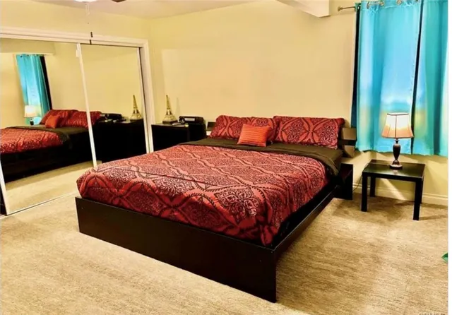 an empty room with closet and a ceiling fan