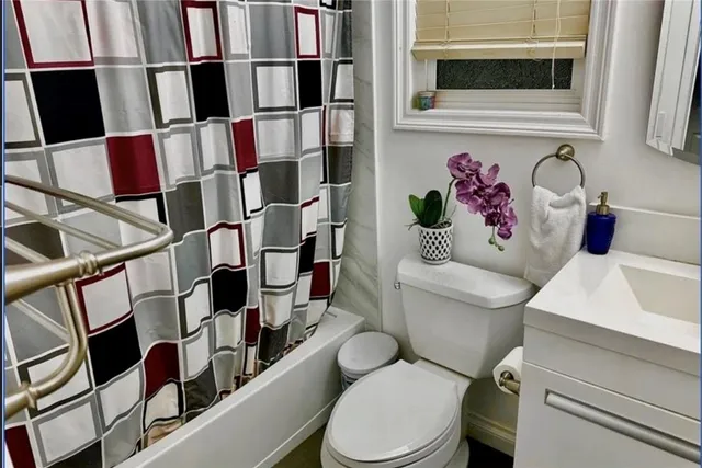 a white toilet sitting next to a white cabinet