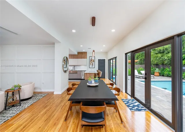 a view of a dining room with furniture a rug and a floor to ceiling window